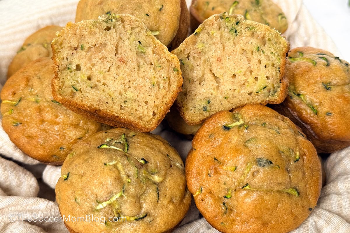 close up on zucchini muffins, with one cut in half to show detail.