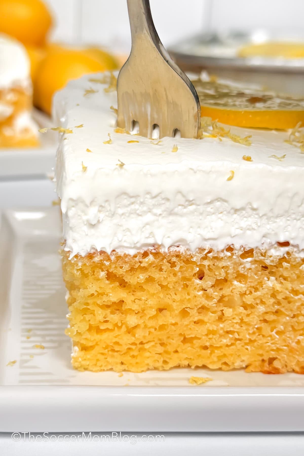 fork taking a bite of a lemon poke cake.