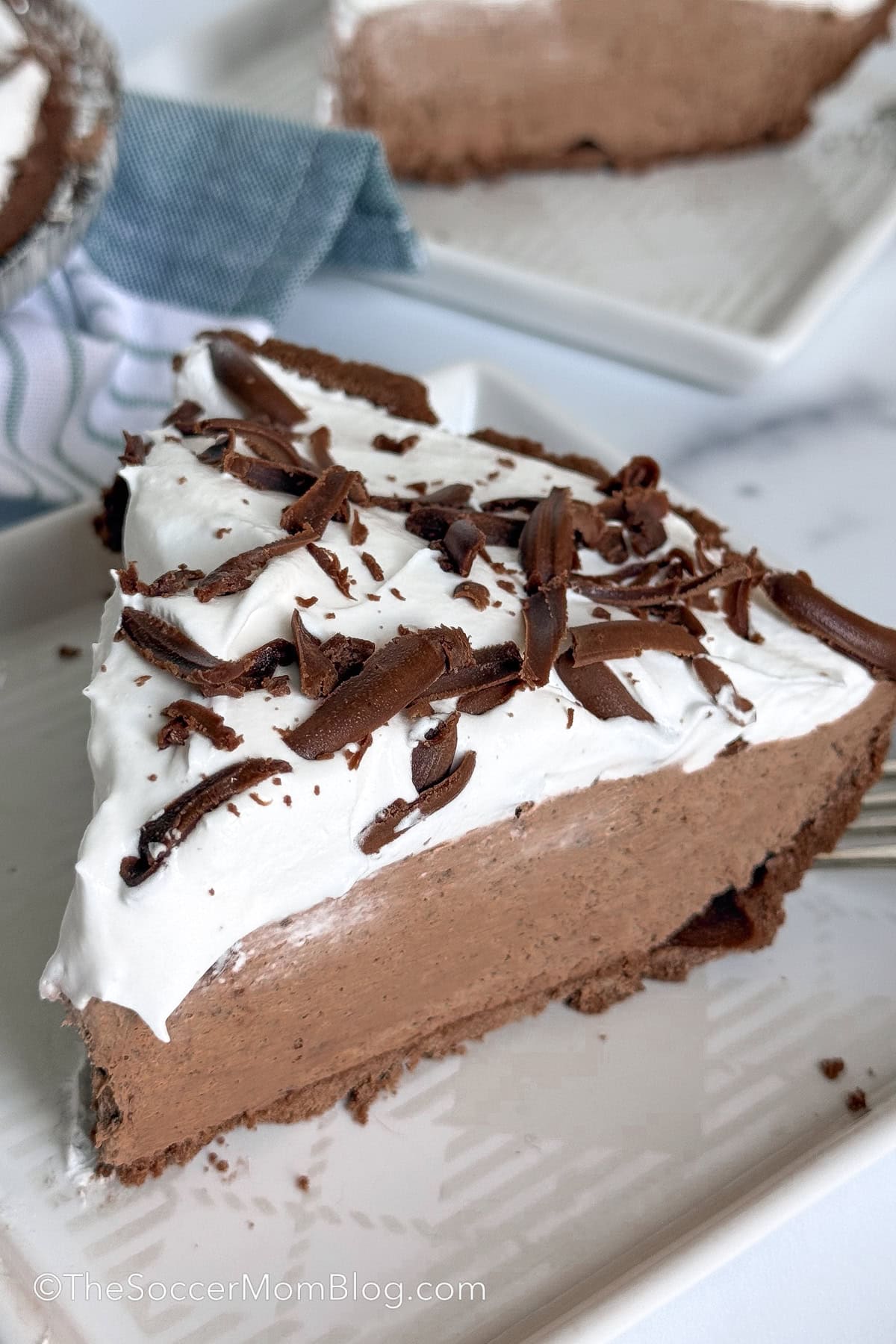close up on a slice of chocolate pie with whipped cream on top.