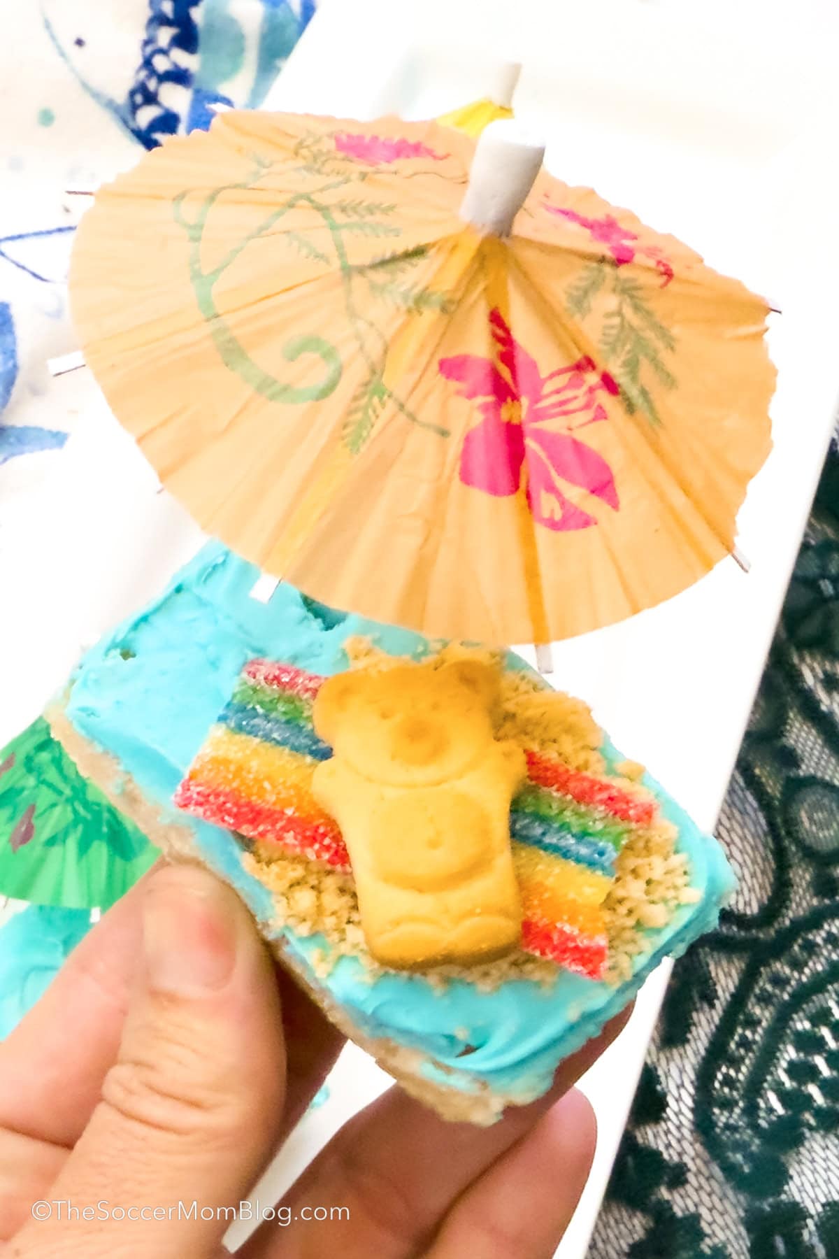 Close up shot of a beach day themed rice krispie treat in hand.
