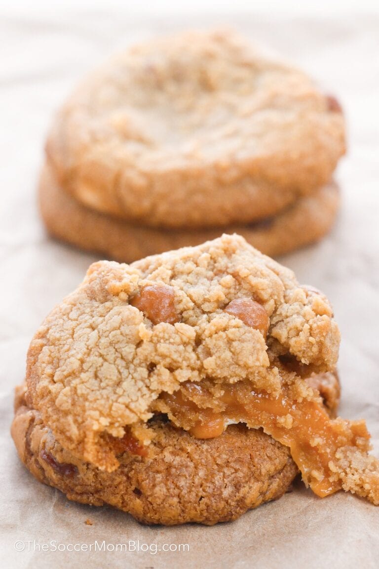 salted caramel cookies, one torn open to show meted caramel inside.