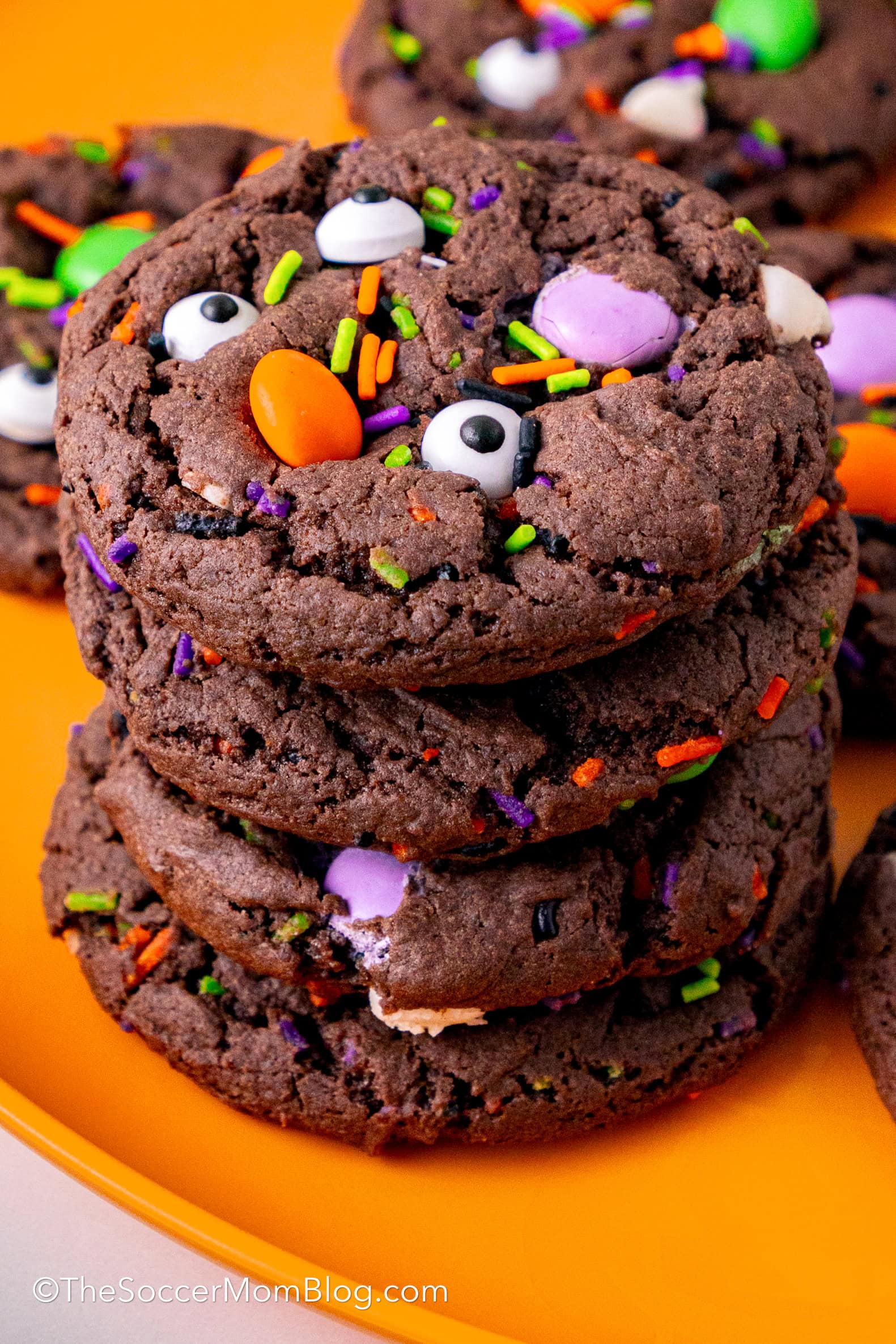 A stack of three Chocolate Halloween cookies loaded with sprinkles and candy eyes.