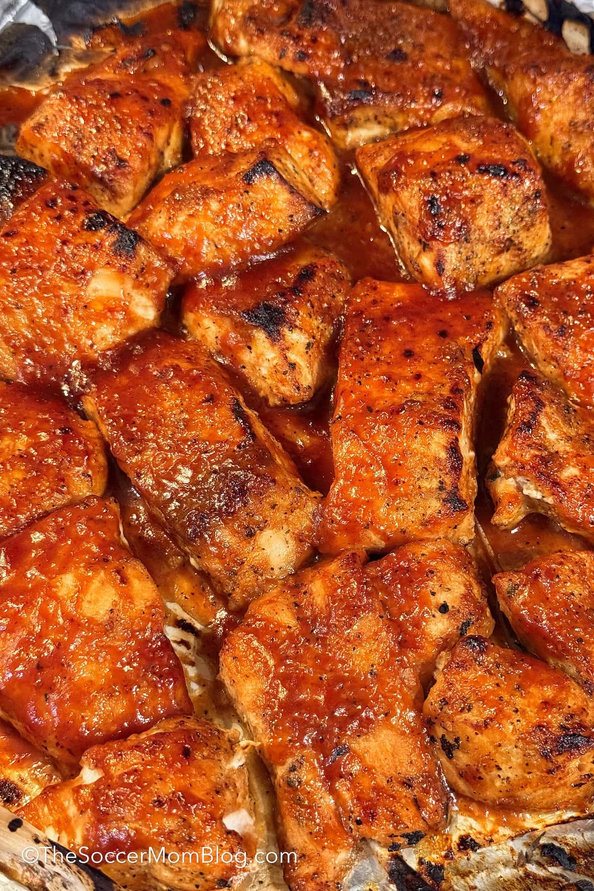 cooked barbecue salmon pieces on a baking sheet