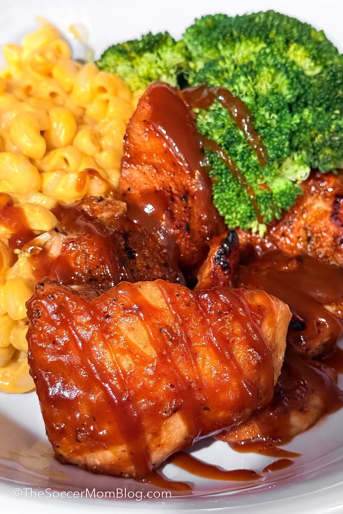 close up of barbecue salmon, served with mac and cheese and broccoli.