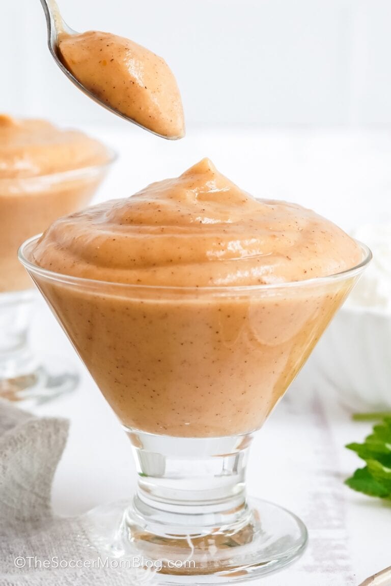 A serving dish of Pumpkin Pudding with a spoon lifting out of it.
