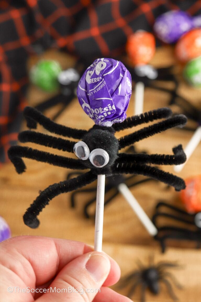 holding a lollipop decorated to look like a spider.